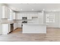 Modern kitchen with stainless steel appliances, white cabinets, and a spacious island at 449 S Salida St, Aurora, CO 80017