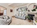 Cozy living room with a fireplace, neutral tones, and ample natural light from the window at 15501 E 112Th Ave # 28E, Commerce City, CO 80022