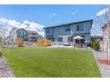 Spacious backyard with green lawn, patio, and privacy fence, ideal for outdoor living at 7240 S White Crow Way, Aurora, CO 80016