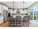 Modern kitchen featuring stainless steel appliances, a center island with barstool seating, and ample cabinet space at 7240 S White Crow Way, Aurora, CO 80016