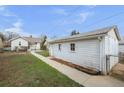 View of detached garage with a long driveway and green grass at 3226 S Grant St, Englewood, CO 80113