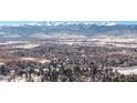 Panoramic aerial view of a town nestled against a backdrop of snow-capped mountains on a clear, sunny day at 4667 Ashfield Dr, Boulder, CO 80301