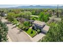 Inviting two-story home with a manicured lawn and mature trees, set against a backdrop of scenic mountains at 4667 Ashfield Dr, Boulder, CO 80301