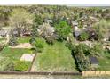 Expansive backyard featuring a lush green lawn, bordered by mature trees and a basketball court, perfect for outdoor enjoyment at 4667 Ashfield Dr, Boulder, CO 80301