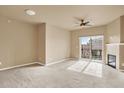 Spacious living room with a cozy fireplace and sliding glass doors to balcony at 1144 Rockhurst Dr # 401, Highlands Ranch, CO 80129