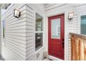 Inviting front entrance with a vibrant red door and modern lighting fixtures at 6366 N Emporia St, Denver, CO 80238