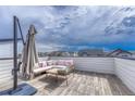 A rooftop deck featuring a seating area with plush pillows, and an umbrella for shade, ideal for relaxation at 6366 N Emporia St, Denver, CO 80238