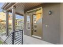 Front door of the house with textured walls, sidelights, an overhead accent window, and a covered porch with support columns at 2564 Sweet Wind Ave, Castle Rock, CO 80109