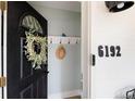 Cozy entryway with black door, leafy wreath, number 6192, and coat rack at 6192 S Pennsylvania St, Centennial, CO 80121