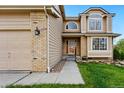 Beautiful home exterior showcasing the entry with manicured lawn, and a three-car garage at 9515 Dolton Way, Highlands Ranch, CO 80126