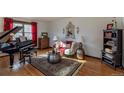 Living room features hardwood floors, piano, and comfy seating at 5221 W Rowland Pl, Littleton, CO 80128