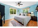 Comfortable bedroom with two windows, hardwood floors, a ceiling fan, and an area rug at 1332 Ash St, Denver, CO 80220