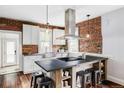 Modern kitchen features exposed brick, custom island and stainless steel appliances at 4430 Zuni St, Denver, CO 80211