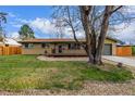 Well-maintained front yard with a lush lawn and a welcoming front porch, creating a picturesque curb appeal at 482 W Caley Ave, Littleton, CO 80120