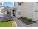 Inviting covered front porch with white railings and a vibrant blue front door at 4670 Tanner Peak Trl, Brighton, CO 80601