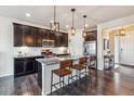 Modern kitchen with dark cabinets, granite island, and stainless steel appliances at 15162 Jakarta Cir, Parker, CO 80134