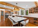 Well-lit kitchen featuring a large island with seating, wooden cabinets, stone countertops and stainless appliances at 110 Windwood Cir, Breckenridge, CO 80424