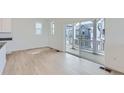 Bright, open-concept room with hardwood floors and a sliding glass door leading to outdoor living space at 2094 S Haleyville Way, Aurora, CO 80018
