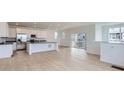 Bright, open-concept living space with hardwood floors, white walls, modern lighting, and sliding glass door to a deck at 2094 S Haleyville Way, Aurora, CO 80018