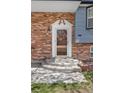 Classic front entrance with decorative doorframe, brick facade, and manicured landscaping at 11506 Fowler Dr, Northglenn, CO 80233