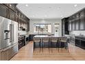 Spacious kitchen featuring an island, seating, stainless steel appliances, and dark cabinets at 815 Promenade Dr, Superior, CO 80027