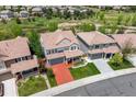 Aerial view showcasing a well-maintained property with lush landscaping, a red driveway, and proximity to green spaces and other homes at 2307 Candleglow St, Castle Rock, CO 80109