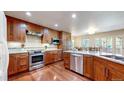 Modern kitchen with stainless steel appliances, custom wood cabinetry, granite countertops, and hardwood flooring at 2990 E 135Th Dr, Thornton, CO 80241