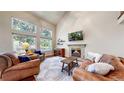 Spacious living room with high ceilings, a cozy fireplace, large windows and comfortable furnishings at 2990 E 135Th Dr, Thornton, CO 80241