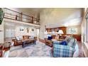 Open-concept living room with hardwood floors, a large rug, comfortable seating, and a view of the upper level at 2990 E 135Th Dr, Thornton, CO 80241