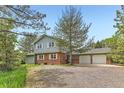 Charming two-story home featuring a brick facade, white shutters, and a spacious three-car garage at 6351 S Andes Pl, Centennial, CO 80016