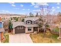 Beautiful exterior view of a home with a large driveway and mountain views in the background at 4 Mountain Ash, Littleton, CO 80127