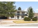 Two-story home with white siding, black trim, second story balcony, and well-maintained landscaping at 11210 Parliament Way, Parker, CO 80138