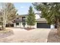 Two-story home with two car garage, white siding, dark trim, and mature trees at 11210 Parliament Way, Parker, CO 80138