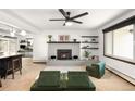 Bright living room featuring a brick fireplace, modern fan, floating shelves, and updated decor at 11210 Parliament Way, Parker, CO 80138