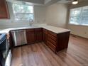 Well-lit kitchen with laminate floors, stainless steel dishwasher, and white countertops at 8040 S Culebra Peak, Littleton, CO 80127