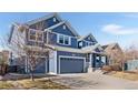 Charming blue two-story home with an attached two-car garage and a welcoming front porch at 1114 Lasnik St, Erie, CO 80516