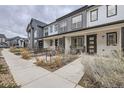 Attractive townhome showcasing neat landscaping and a cozy front seating area at 9269 Garnett St # C, Arvada, CO 80007