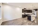 Modern kitchen with stainless steel appliances and island, adjacent to a dining area at 9269 Garnett St # C, Arvada, CO 80007