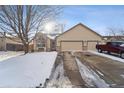Inviting single-Gathering home with an attached two-car garage and a spacious driveway, with a snow-covered yard at 1025 Birch Ave, Fort Lupton, CO 80621