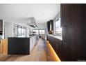 A modern kitchen with stainless steel appliances and dark wood cabinets boasts an open floorplan and hardwood floors at 3112 Braun Ct, Golden, CO 80401
