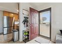 Entryway showcasing tiled floors, and an open floor plan with a view of the stainless steel refrigerator in the adjacent kitchen at 23376 E 5Th Pl # 201, Aurora, CO 80018