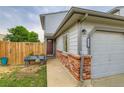 Inviting townhouse entrance featuring a red door, brick accents, and green lawn at 12556 Elm St, Thornton, CO 80241