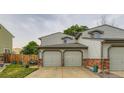 Charming townhouse with two-car garage, red brick accents and lush green lawn at 12556 Elm St, Thornton, CO 80241