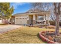 Inviting home featuring a manicured lawn, a two-car garage, and a charming front porch at 13124 Ivy Pl, Thornton, CO 80602