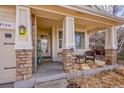Cozy front porch featuring stone columns and comfortable seating, perfect for relaxing outdoors at 13124 Ivy Pl, Thornton, CO 80602
