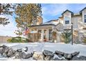 Townhouse exterior with snowy landscaping and stone wall at 961 S Evanston Cir, Aurora, CO 80012