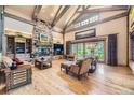 Inviting living room features a stone fireplace, exposed beams, and hardwood floors at 8576 Niwot Meadow Farm Rd, Niwot, CO 80503