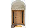 Modern wooden front door with sidelights and arched stone surround welcomes you home at 175 S Jasmine St, Denver, CO 80224