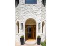 Elegant stone-clad entryway featuring an arched doorway, black planters, and stylish lighting, creating a welcoming first impression at 175 S Jasmine St, Denver, CO 80224