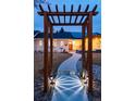 Welcoming walkway leading to the front door, framed by a wooden arbor at 14117 W 58Th Pl, Arvada, CO 80004